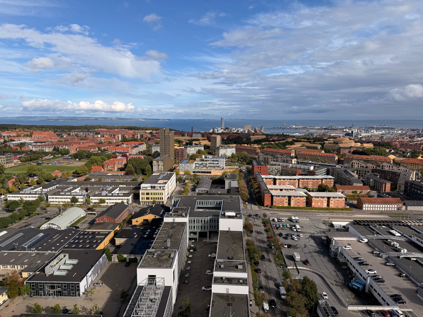 Aerial view of Aarhus, looking across terracotta roofs toward the harbour and sea.